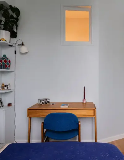 Chambre avec bureau en bois et chaise bleue