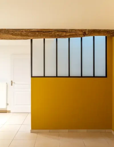 Intérieur avec mur jaune et poutre en bois